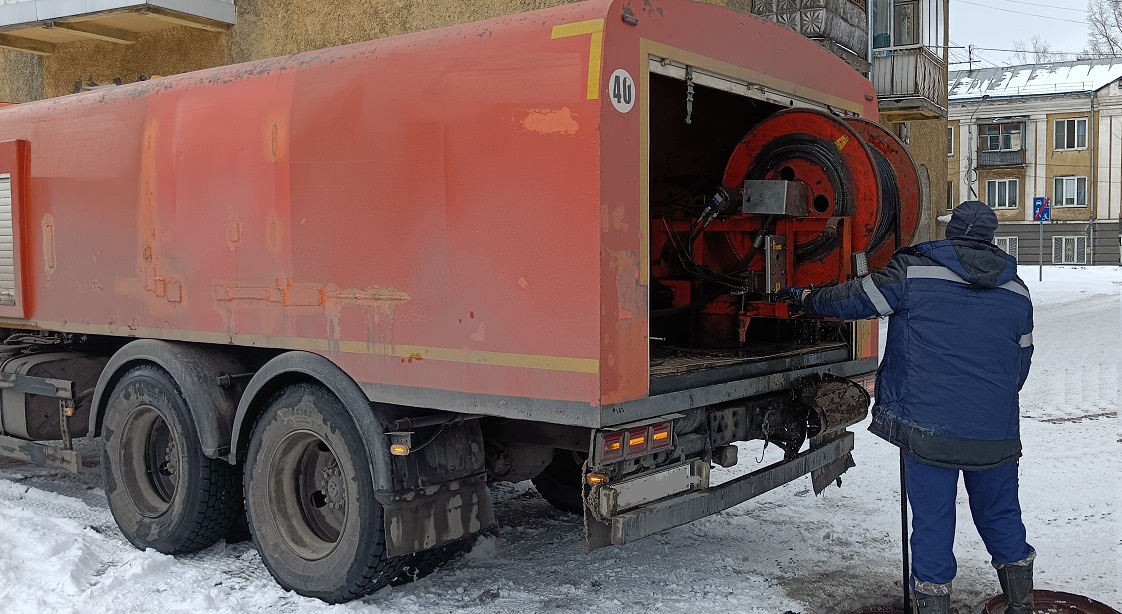 Каналопромывочная машина и работник прочищают засор в канализационной системе в Зубовой Поляне